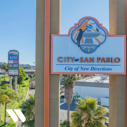 City of San Pablo welcome sign displaying “City of New Directions” with palm trees and commercial businesses visible in the background.