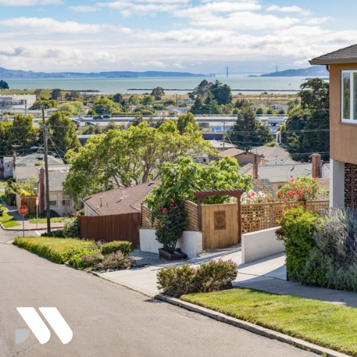 Residential neighborhood in Richmond, California overlooking San Francisco Bay with homes, landscaping, and waterfront views in the distance.