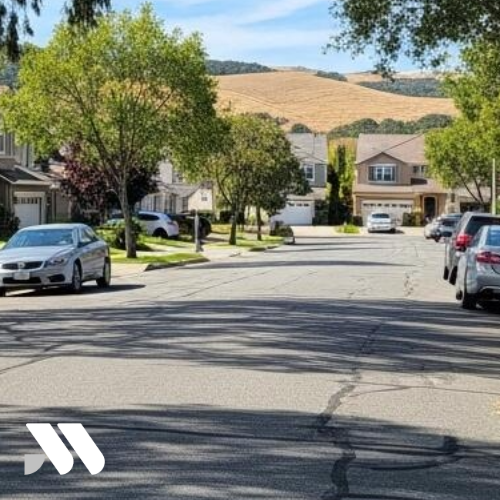 Residential neighborhood in Rodeo, California featuring single-family homes, tree-lined streets, and rolling East Bay hills in the background.