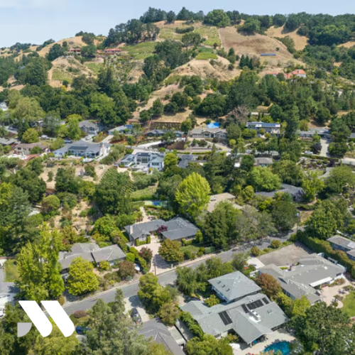 Aerial view of hillside homes and residential neighborhoods in Orinda, California, surrounded by trees and open space.