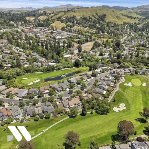 Aerial view of a residential neighborhood and golf course in Lafayette, California, surrounded by rolling hills and suburban homes.