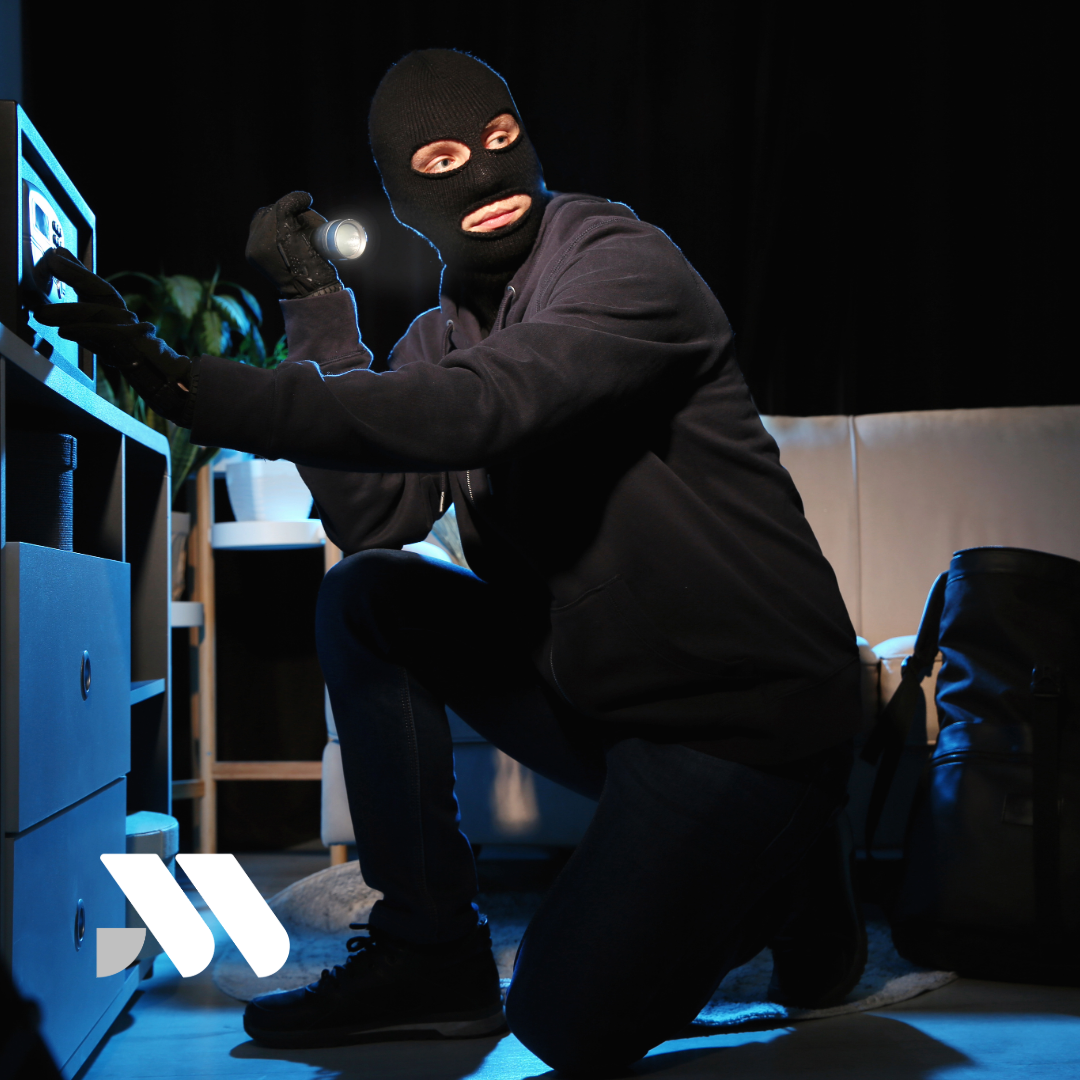 Masked burglar attempting to steal valuables inside a home, illustrating the importance of homeowners insurance coverage for theft and burglary losses.