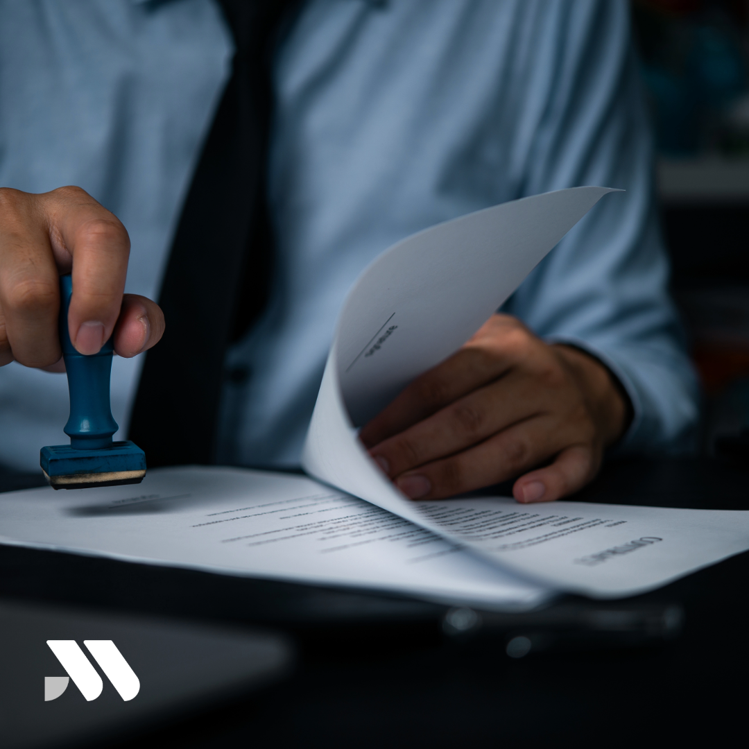 Professional notary public reviewing loan documents and insurance paperwork during a client signing appointment, highlighting insurance and bonding needs for notary businesses.